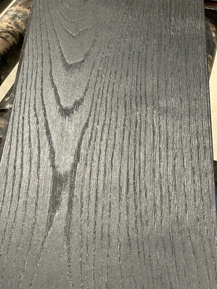 Close-up of a gray textured fabric with vertical ribbed and woodgrain-like patterns