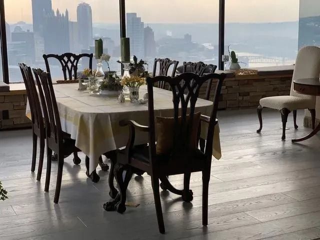 Elegant dining table by large windows overlooking a city skyline at sunset