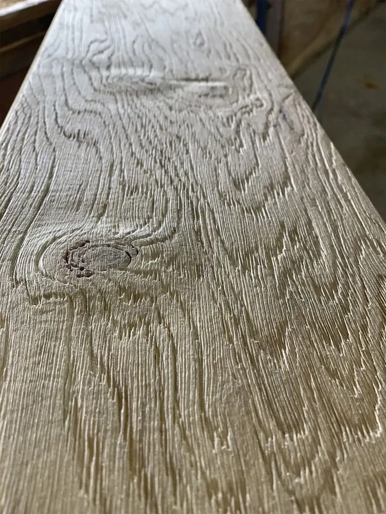Close-up of a weathered wooden board with visible grain and knots