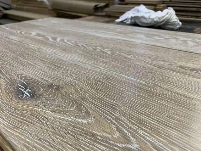 Wood-patterned tabletop with a crumpled white cloth in the background