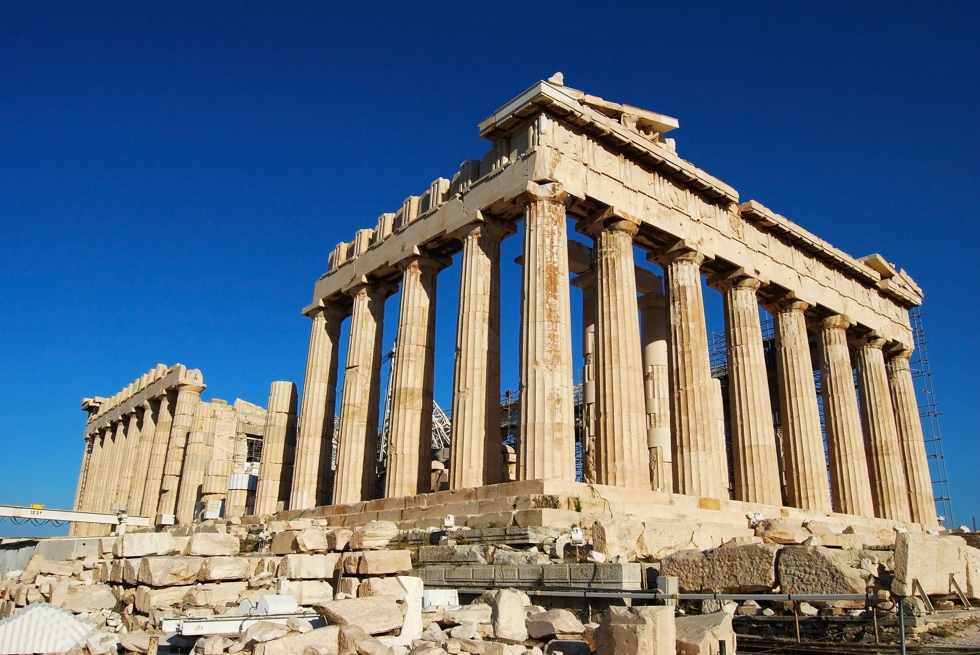 Parthenon temple ruins on a rocky hill under a clear blue sky