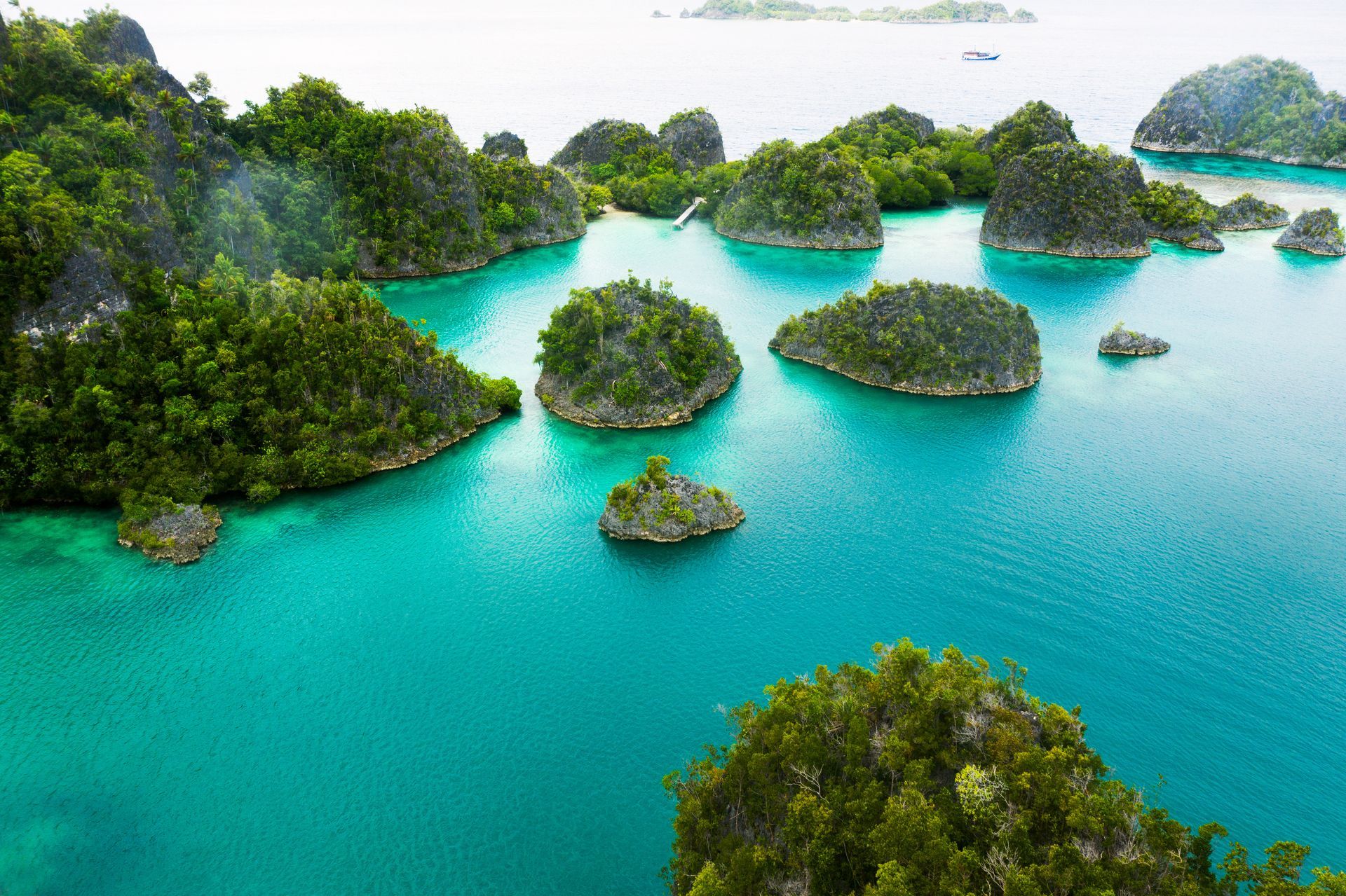 Turquoise lagoon dotted with lush green limestone islands under a bright sky