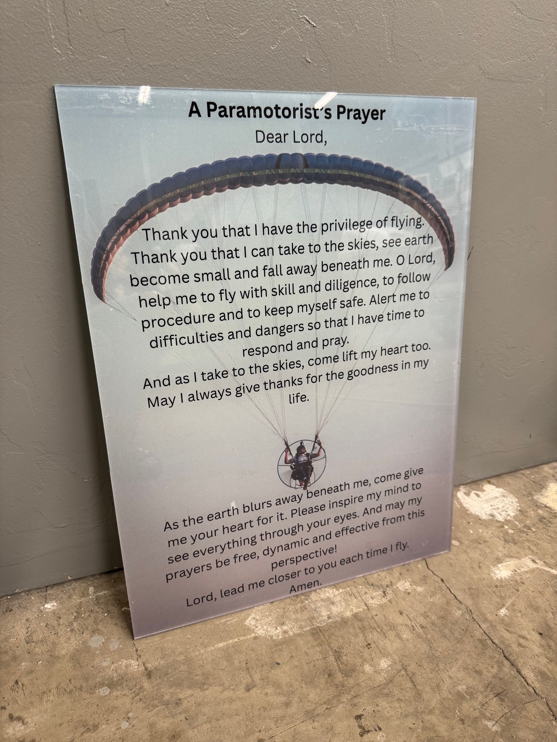 Sign with a paraglider graphic and 