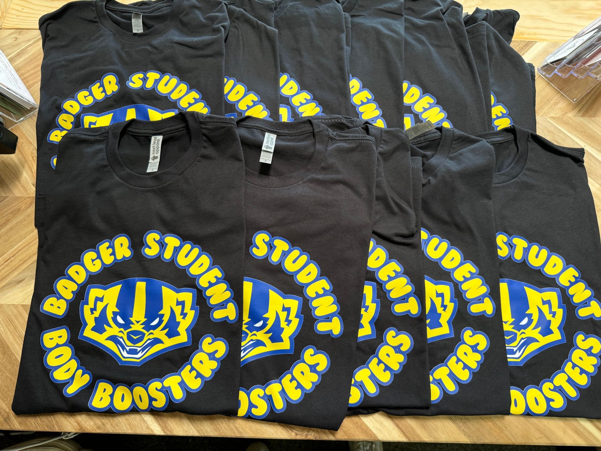 Black t-shirts with a Badger logo and text: 