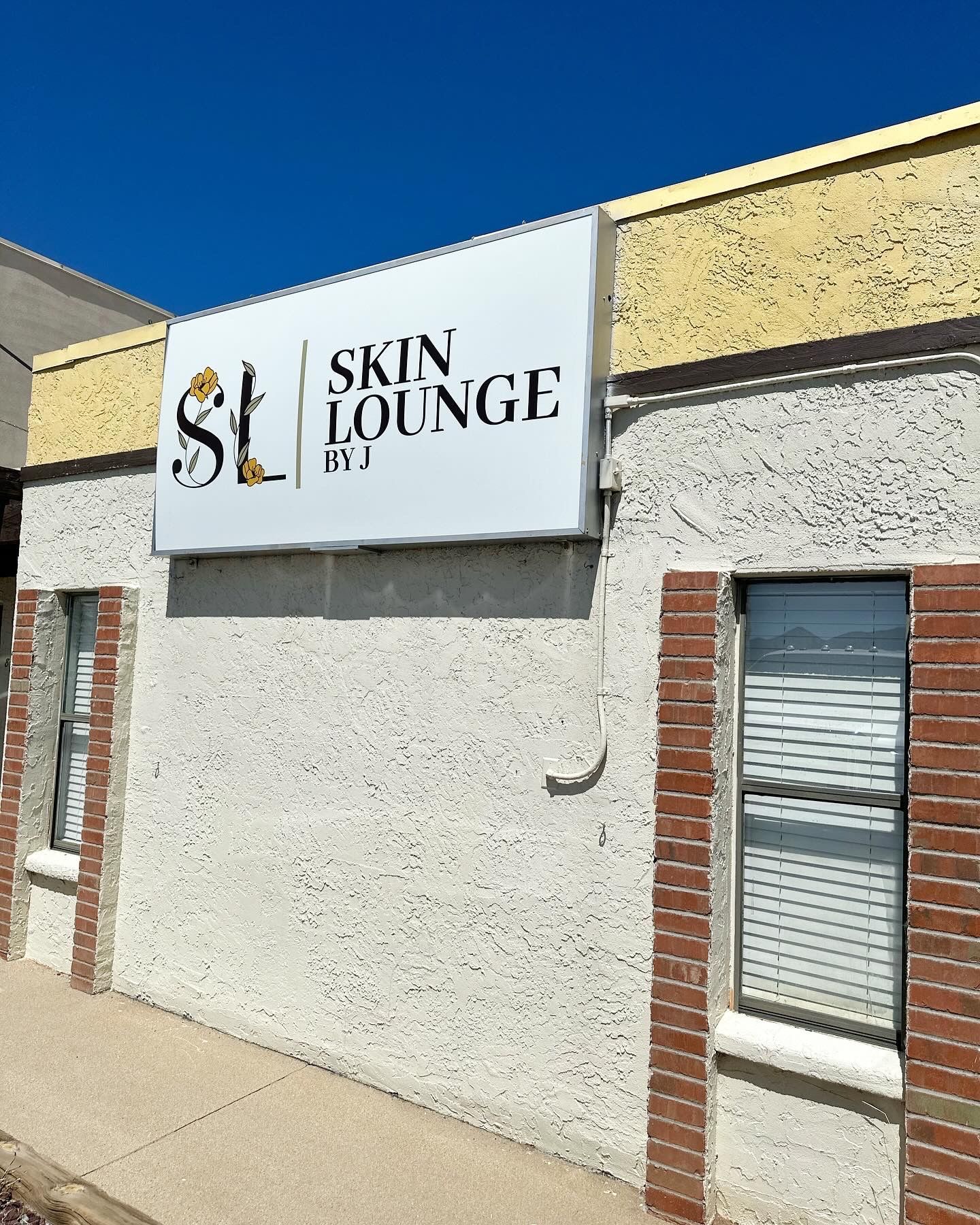 Exterior of Skin Lounge PYJ storefront with a white sign and windows.