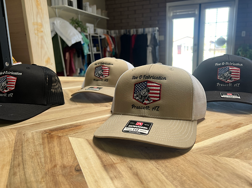 Four baseball caps with an American flag design on a wooden table.