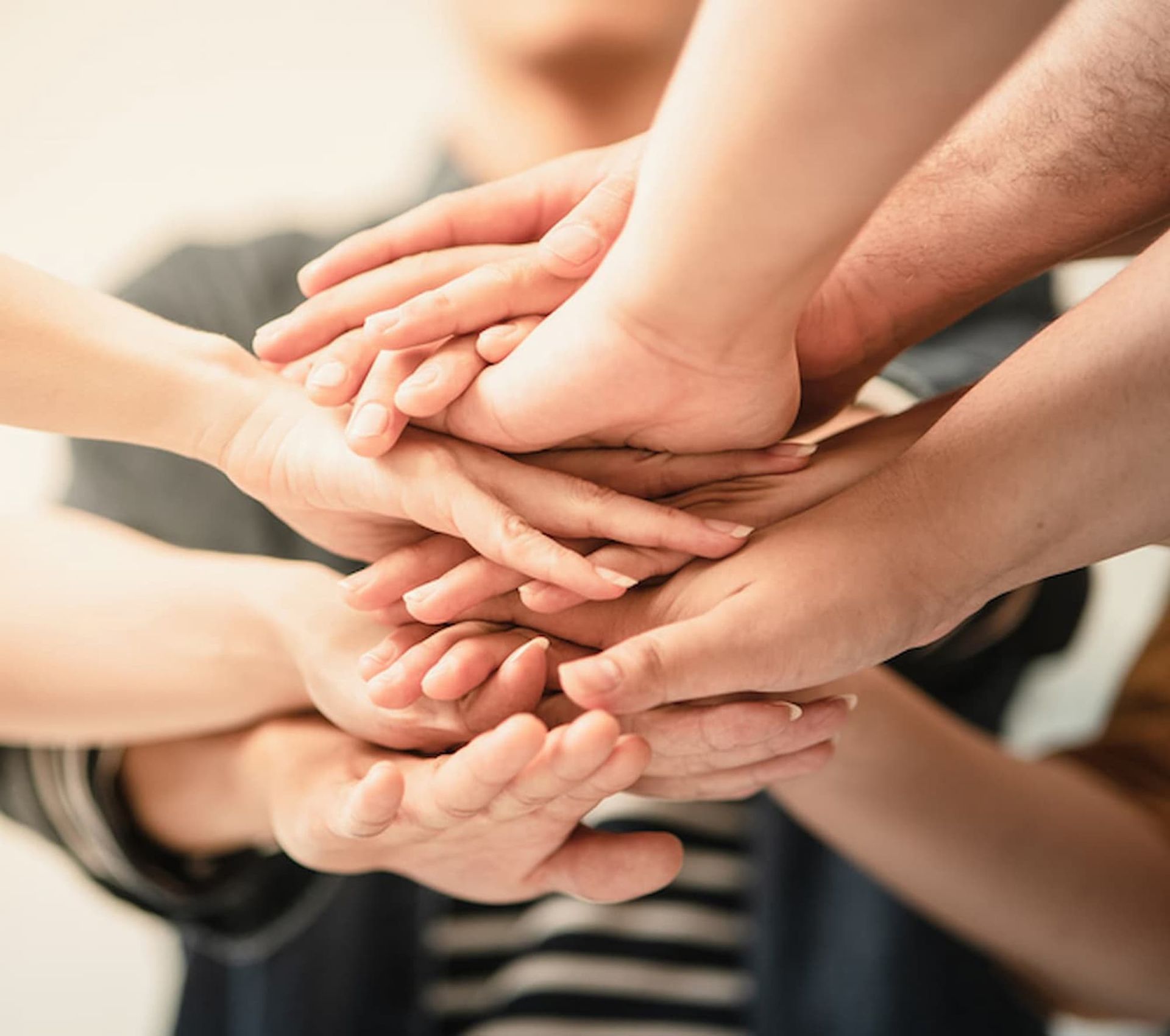 A Group of People Are Putting Their Hands Together — Psych Solutions NT in Leanyer, NT