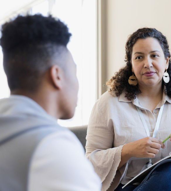 A woman is sitting in a chair talking to another woman. — Psych Solutions NT in Leanyer, NT