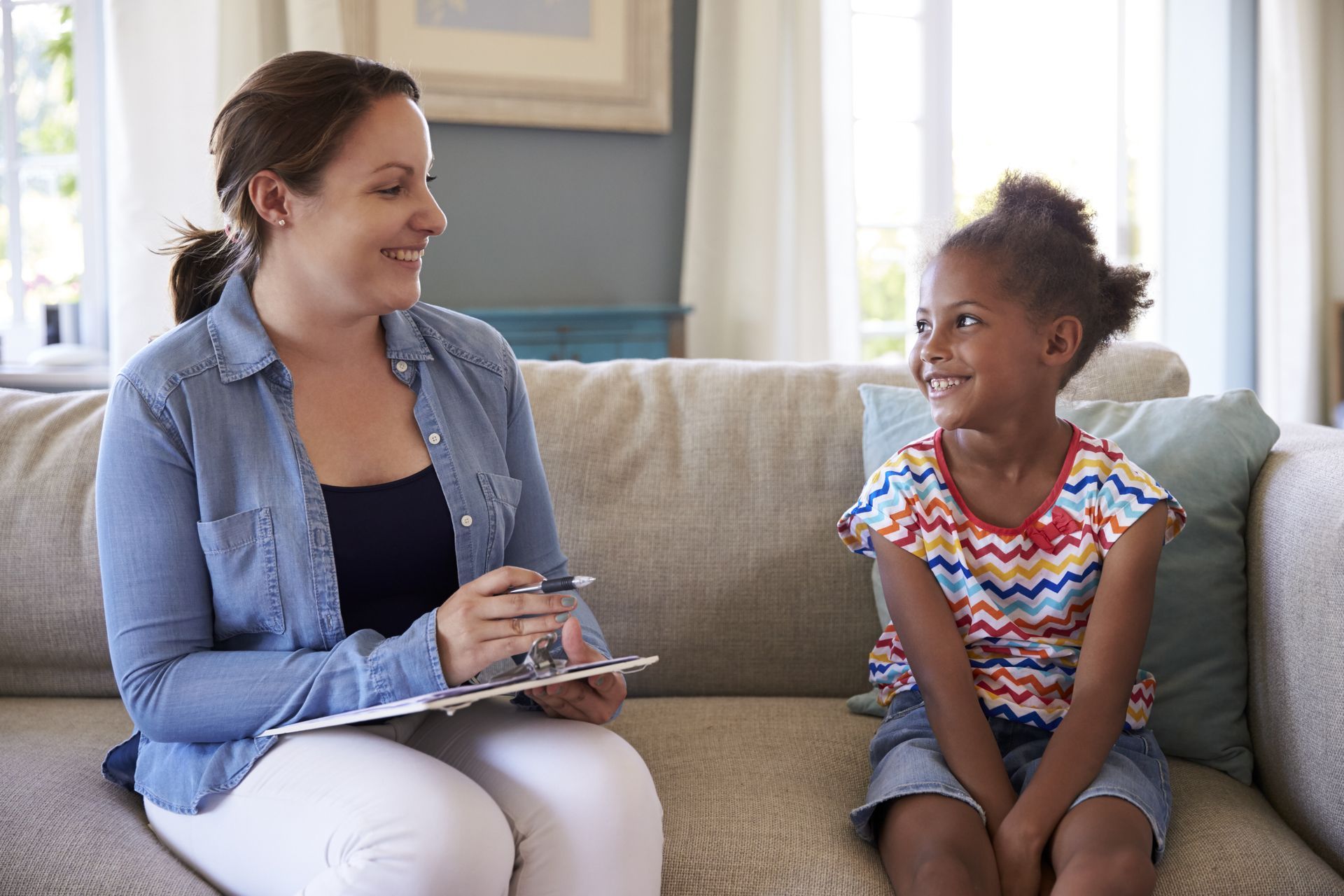 A woman is sitting on a couch talking to a little girl.  — Psych Solutions NT in Leanyer, NT
