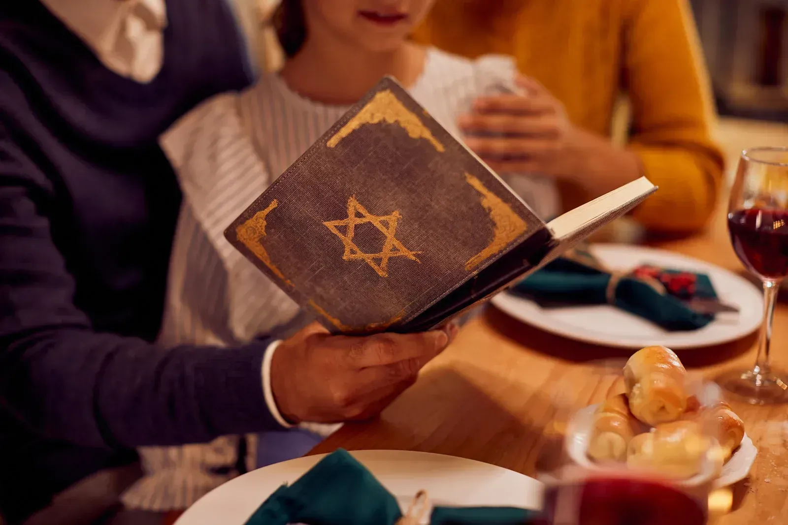 Open book with gold star on a table during a candlelit dinner