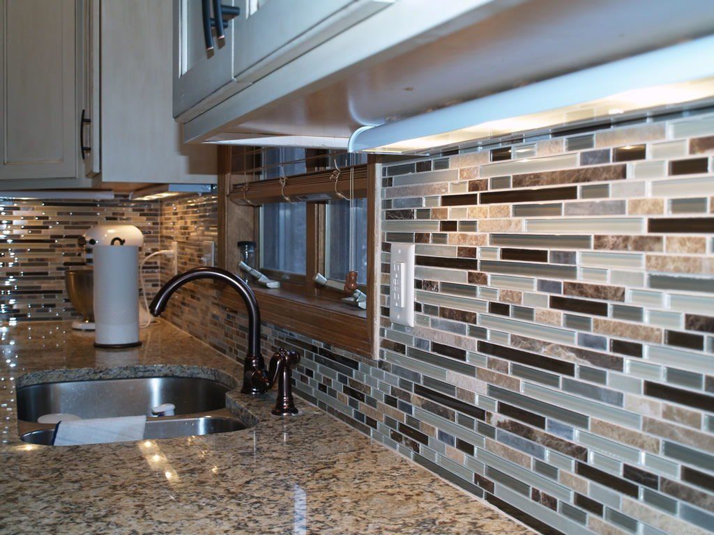 Kitchen with granite countertop, tiled backsplash, sink, and faucet.