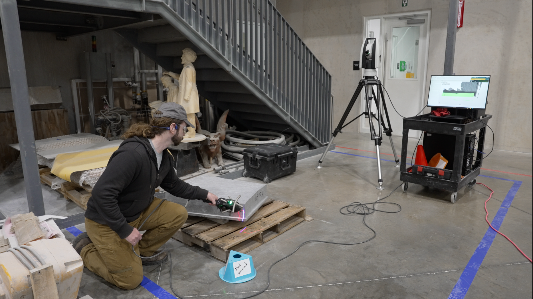 A technician at Quarra Stone Co. scans a granite paver to check the accuracy of work done by robotic carving machines.