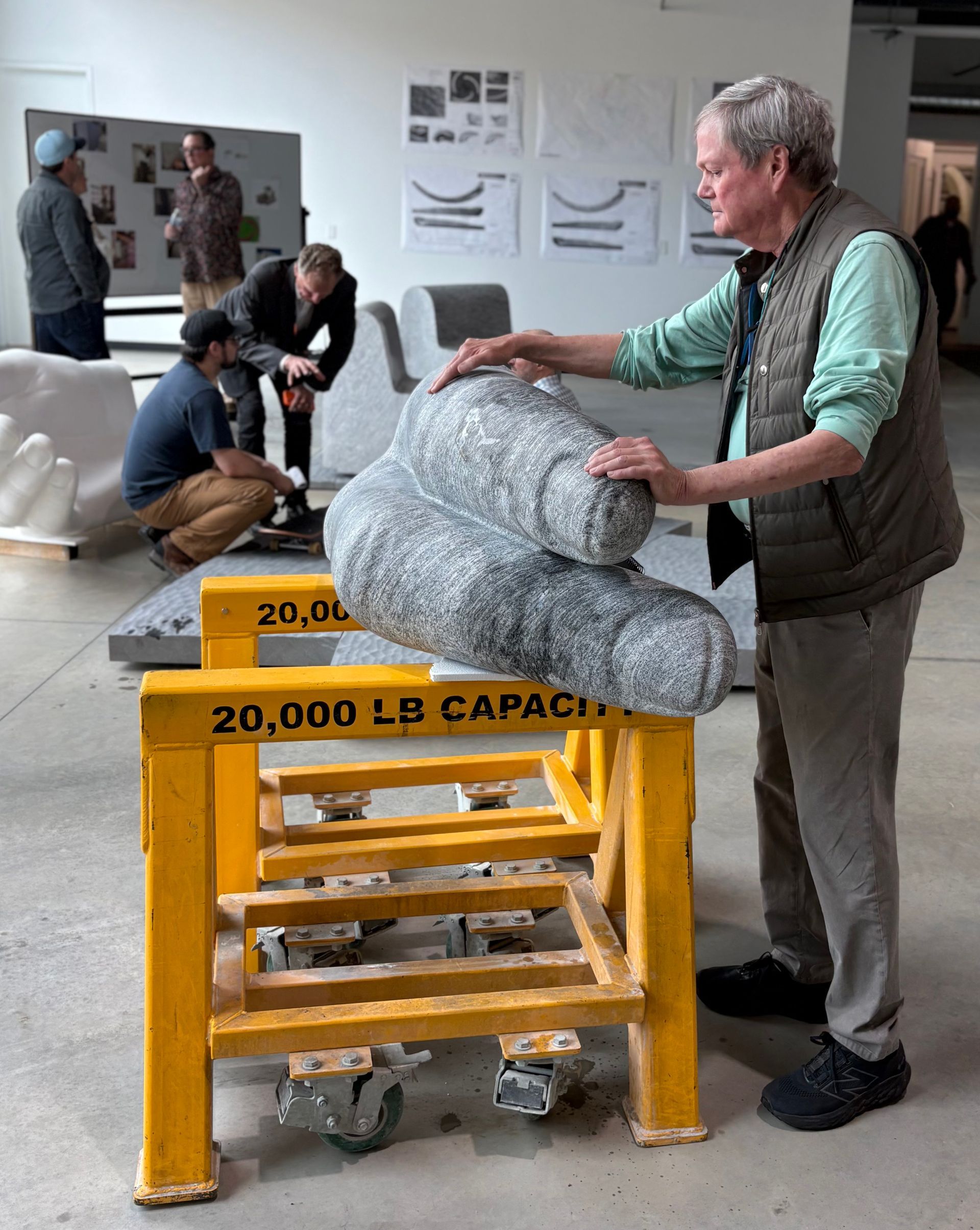 Designer Larry Kirkland evaluates a mockup of the carved finger shapes from the benches' hand-forms.