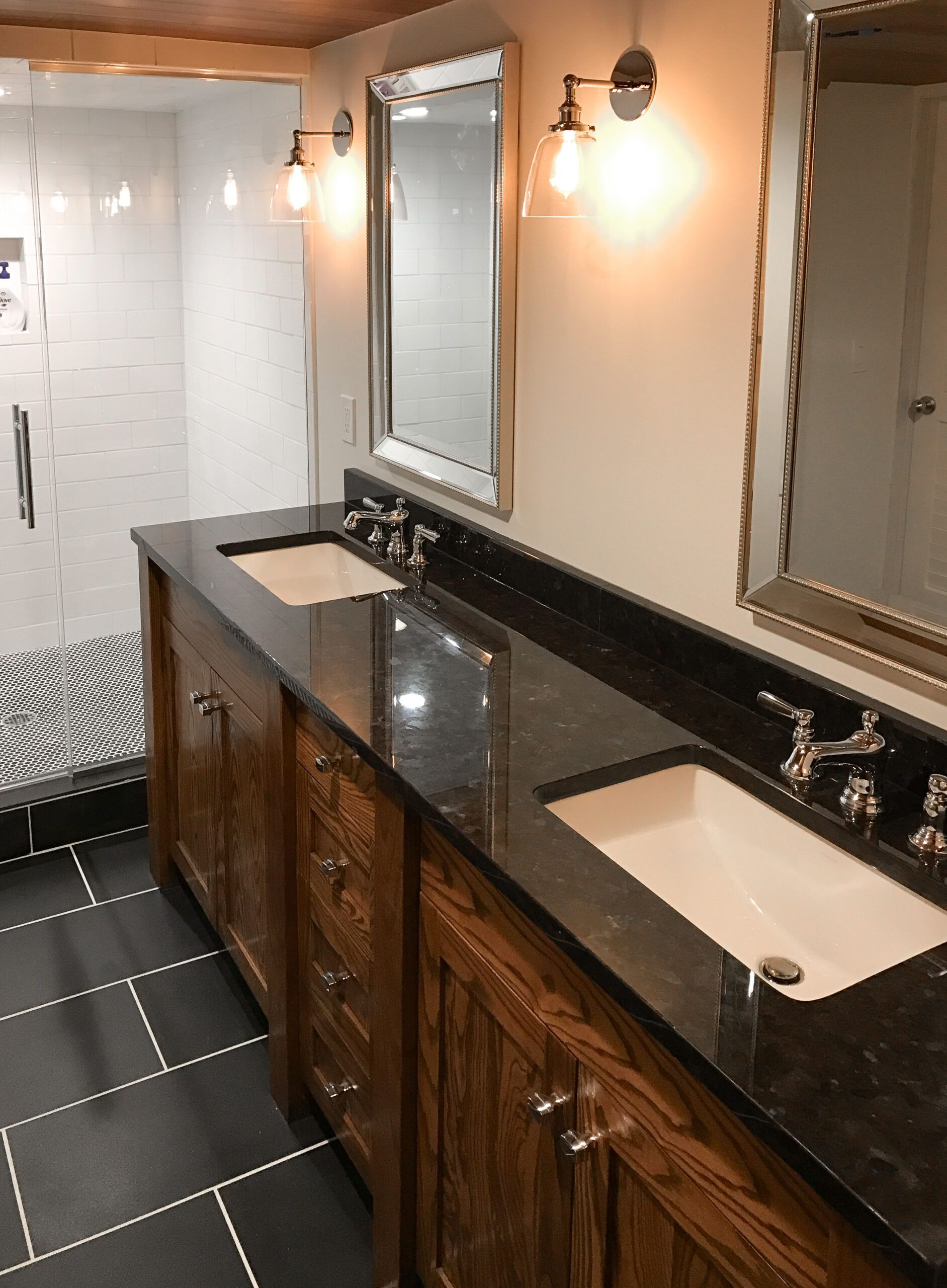 Small bathroom with toilet, sink cabinet, gray rug, and glass walk-in shower.