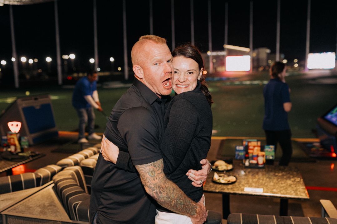 A man is holding a woman in his arms at a party.