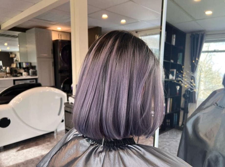 A woman is getting her hair cut in a salon.