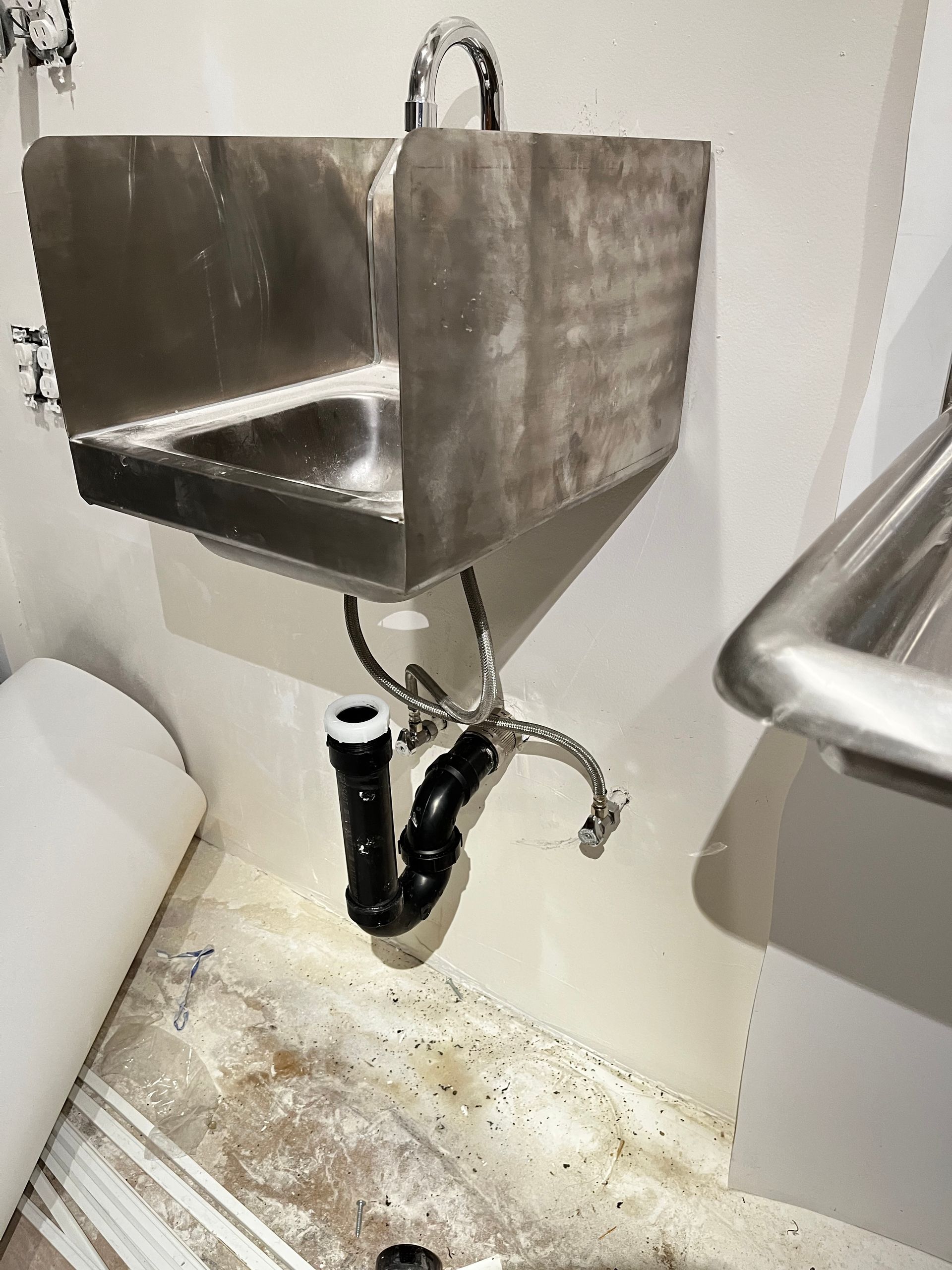 Gloved hands holding a spray gun in a metal industrial interior with bright warm lighting