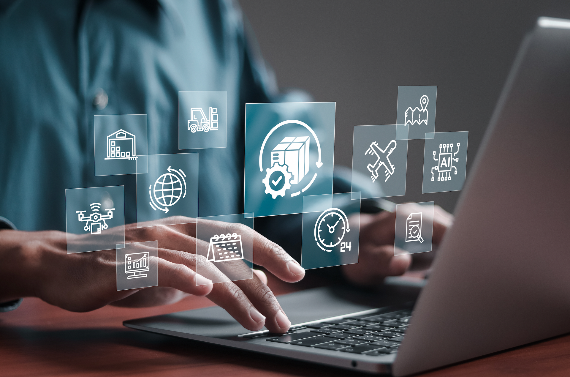 A person is typing on a laptop computer with a bunch of icons coming out of it.