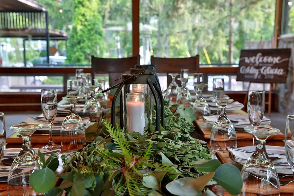 A long wooden table with a lantern and a candle on it.