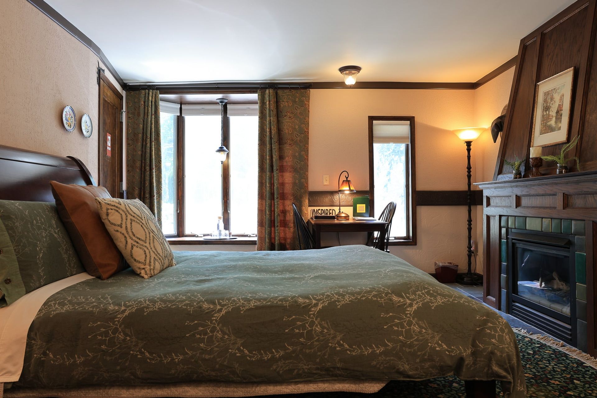 A bedroom with a large bed and a fireplace