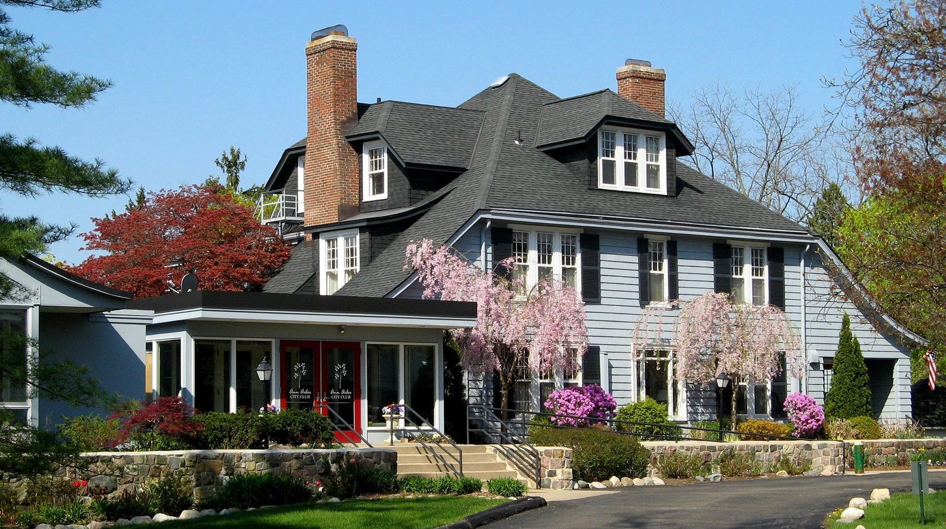 A large house with a black roof and white shutters