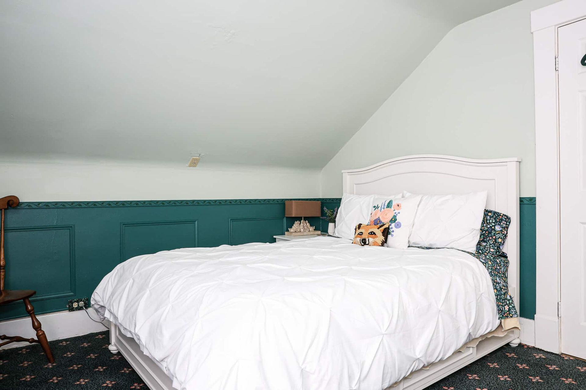 A bedroom with a bed and a chair in it.
