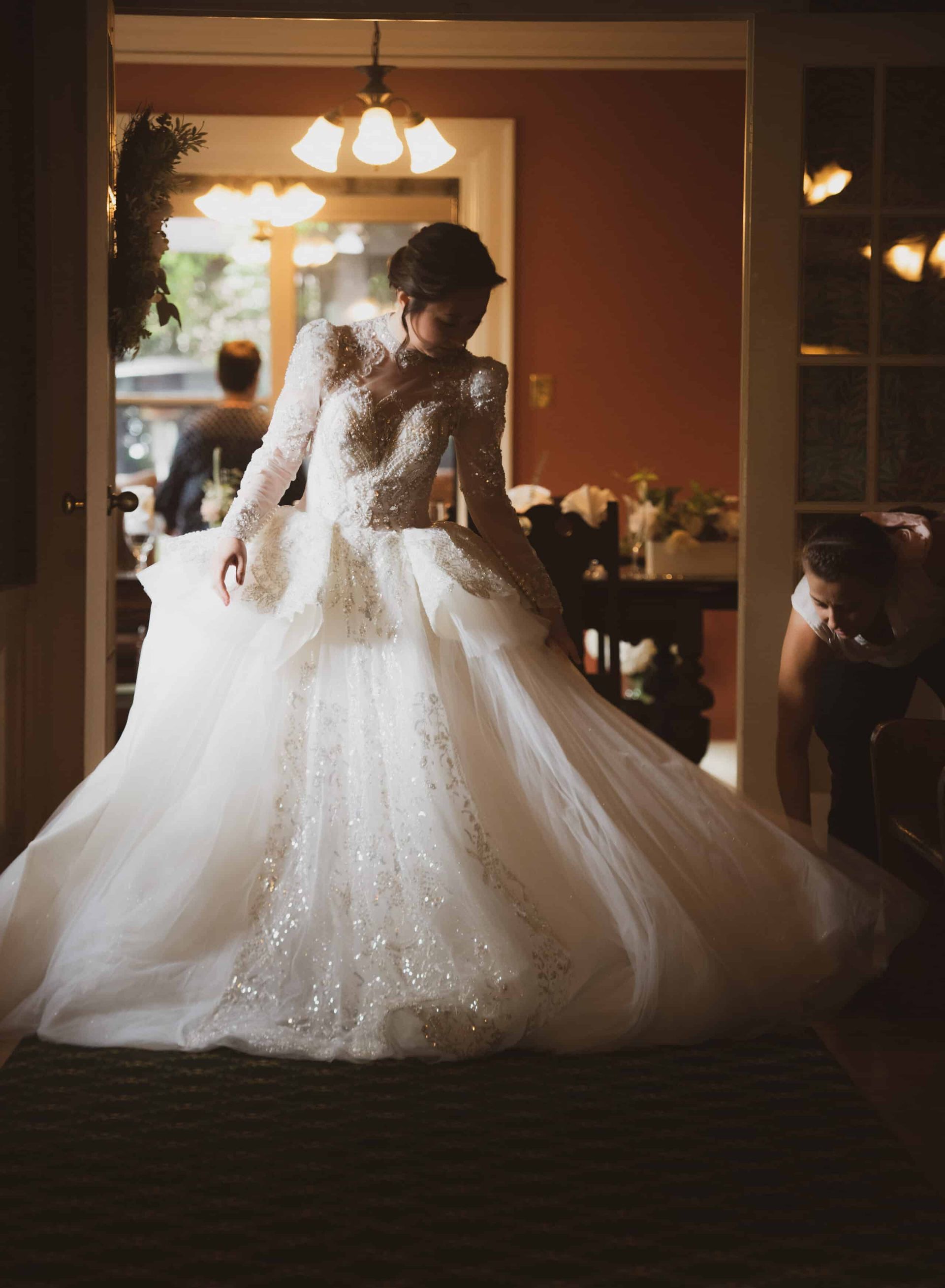 A woman in a wedding dress is standing in a room.