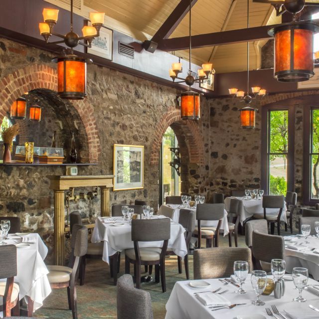 A restaurant with tables and chairs and lanterns hanging from the ceiling