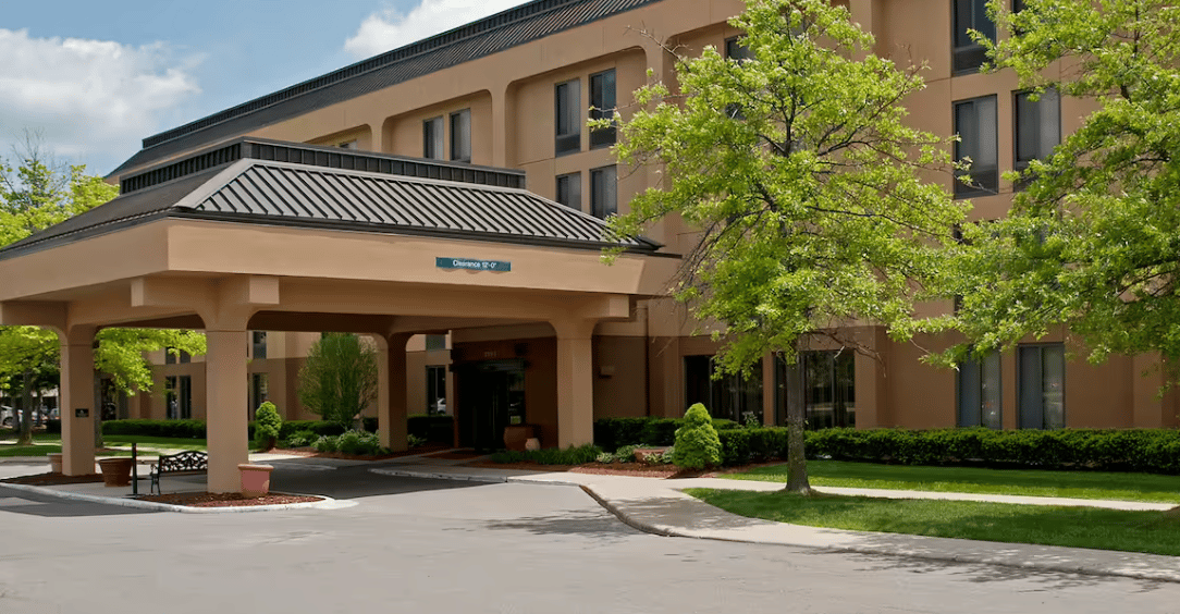 A large hotel with a lot of windows and trees in front of it.