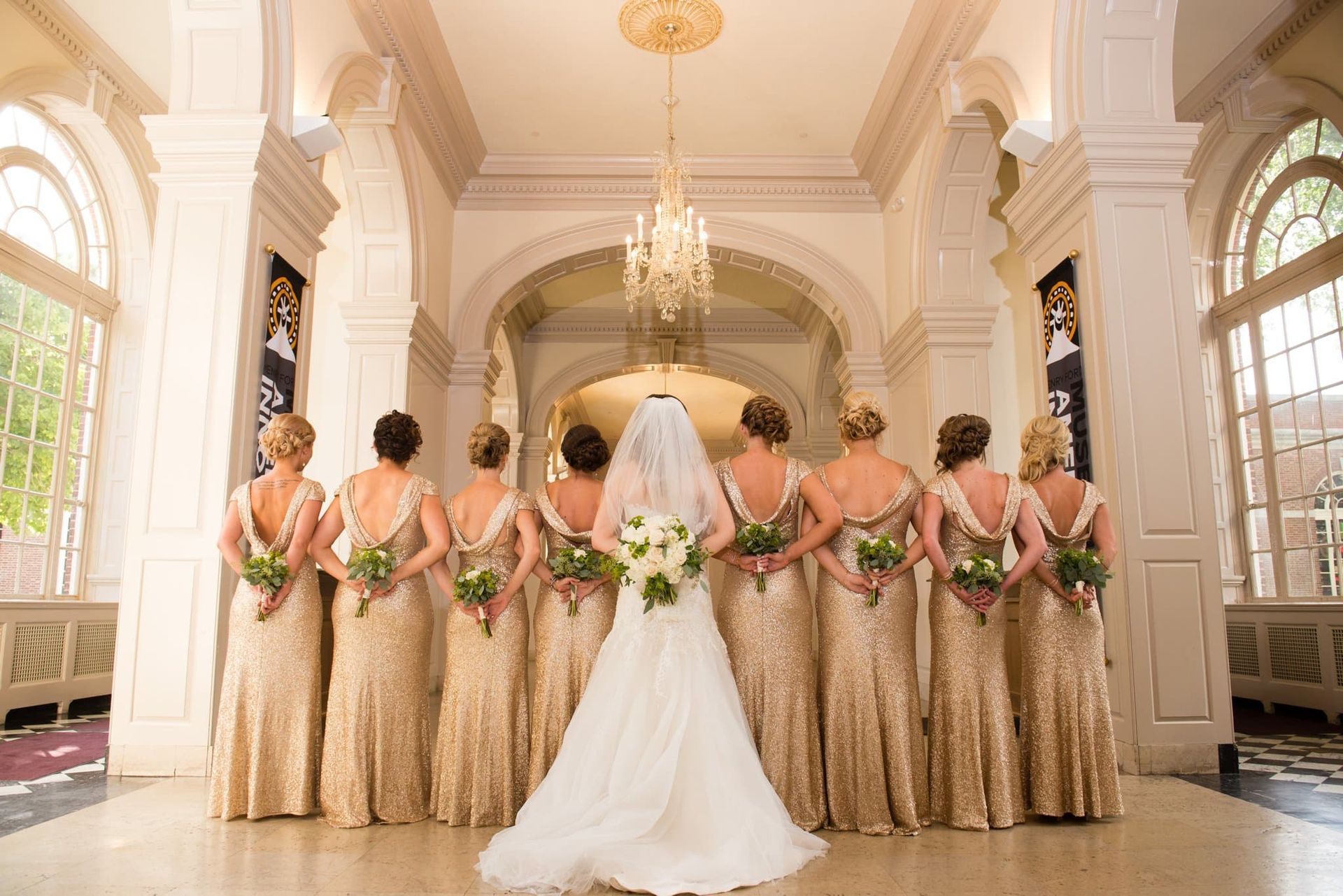 A bride and her bridesmaids are posing for a picture in a hallway.
