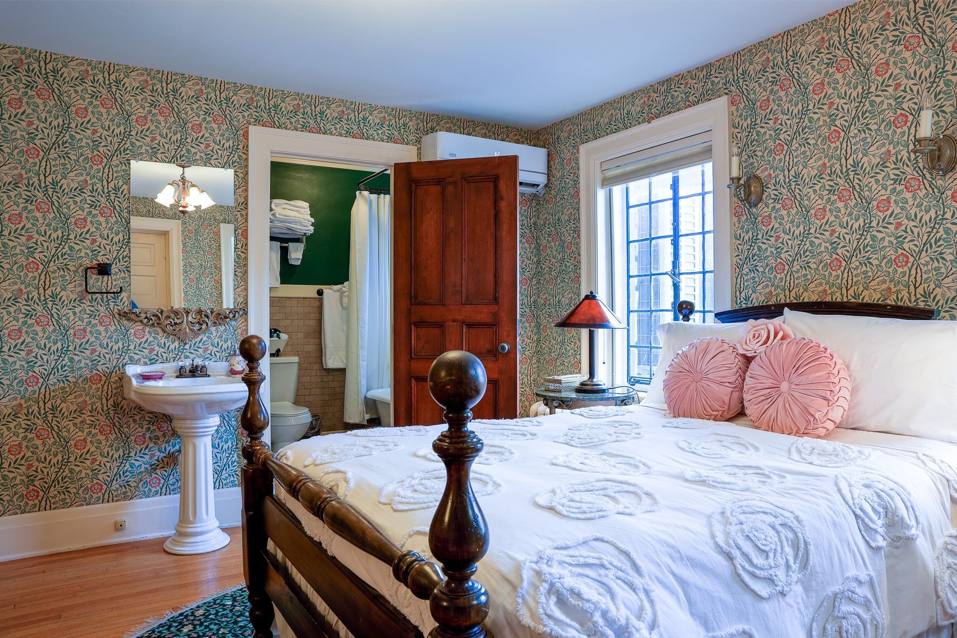 A bedroom with a bed , sink , and window