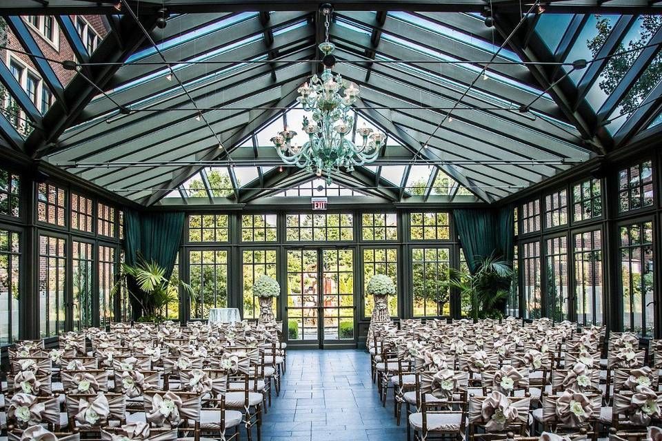 A large room filled with chairs and tables for a wedding ceremony.