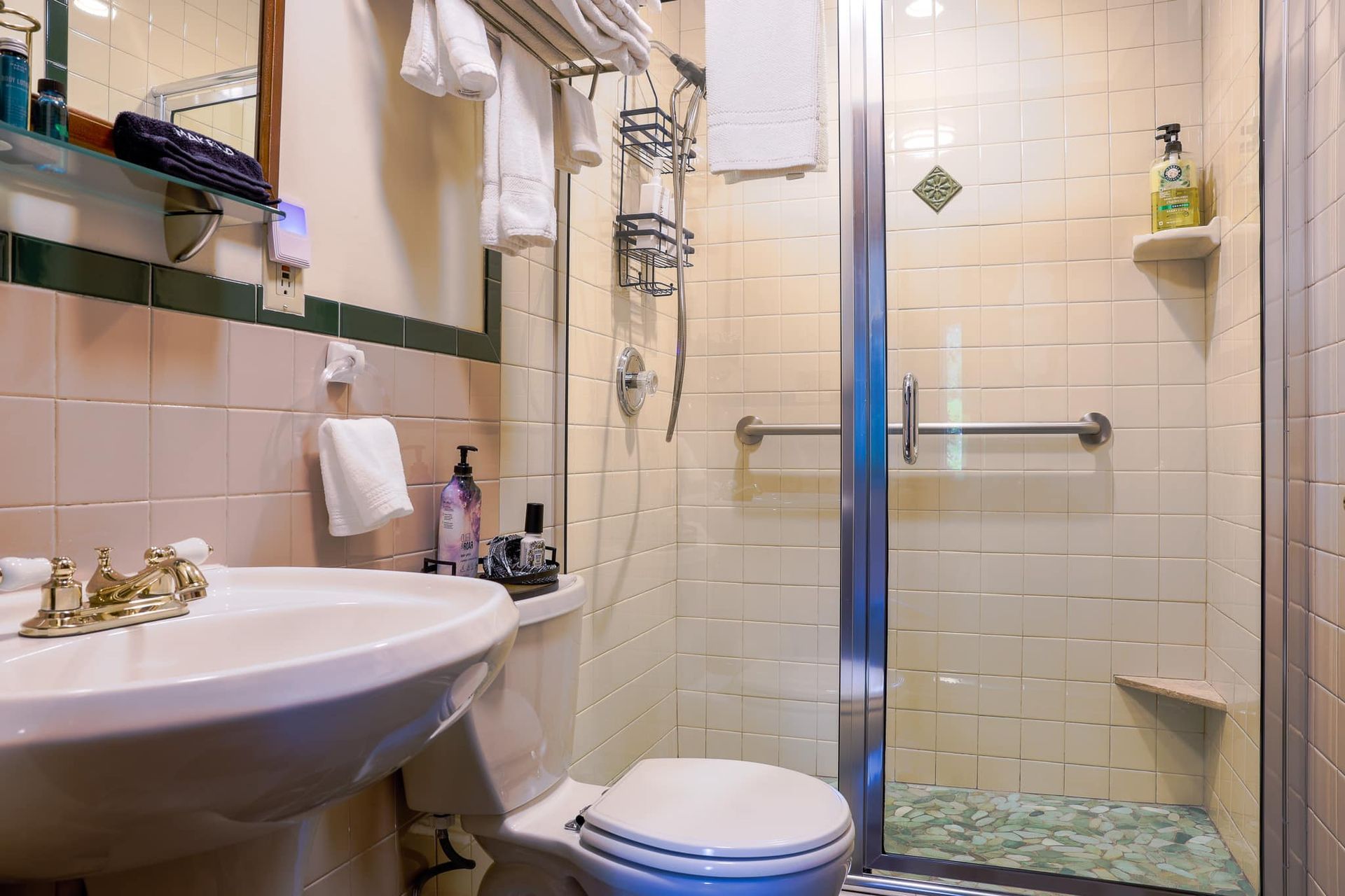 A bathroom with a toilet , sink and walk in shower.
