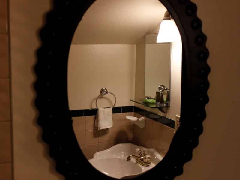 A bathroom with a sink and a mirror with a black frame