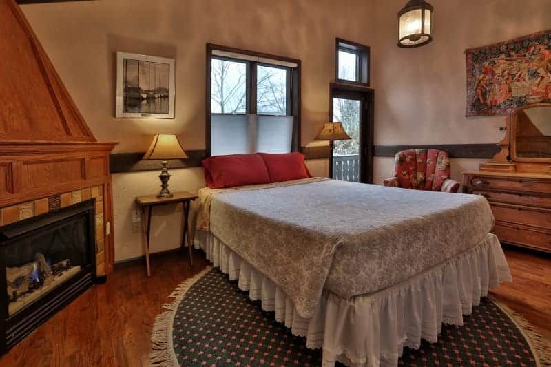 A bedroom with a king size bed and a fireplace