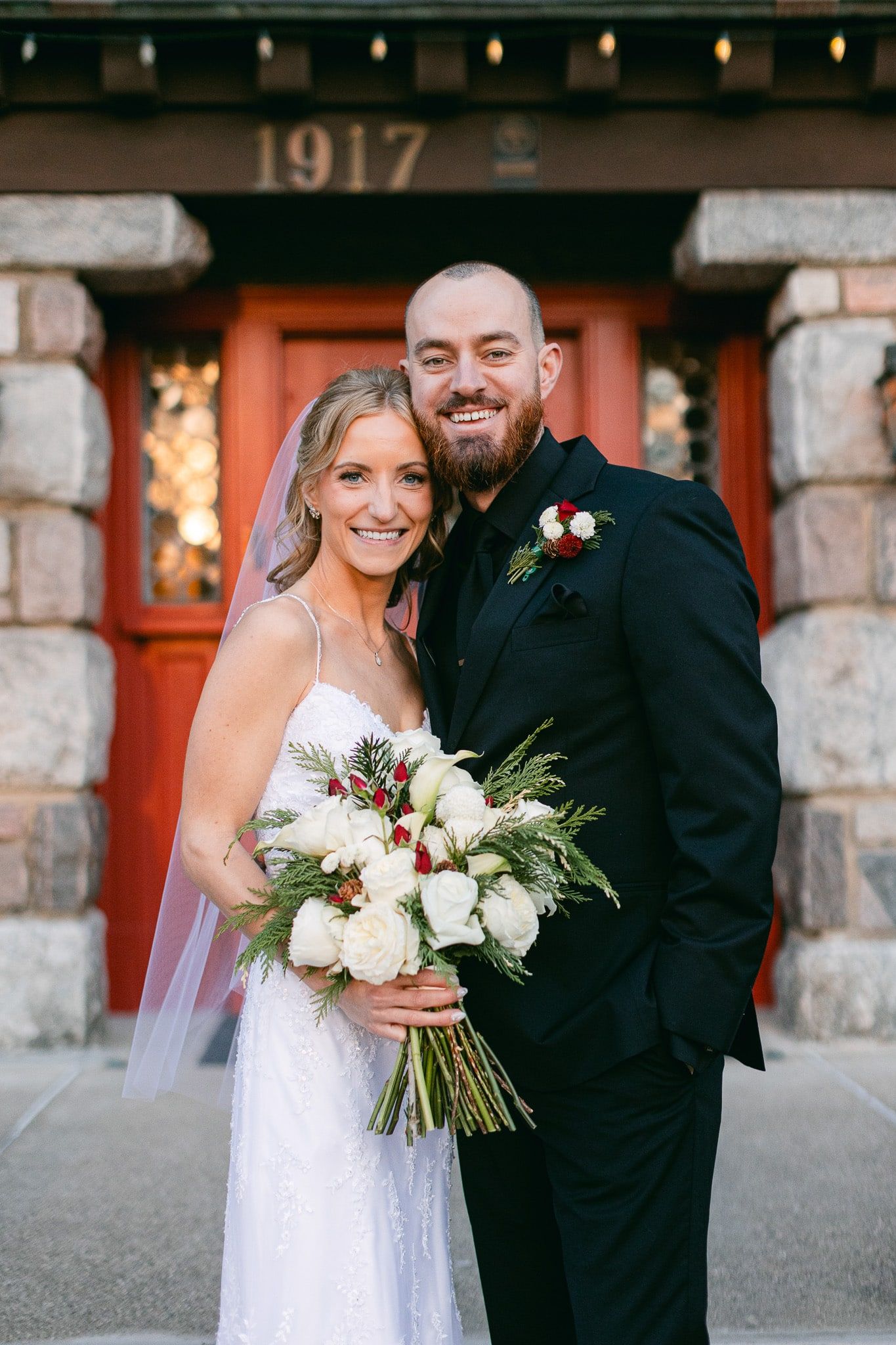 A bride and groom are posing for a picture in front of a building.