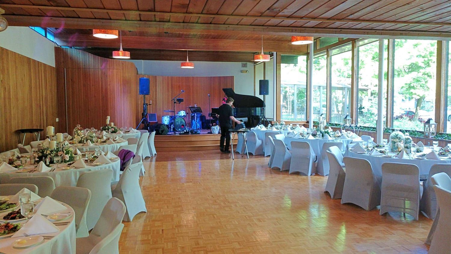 A large room with tables and chairs set up for a wedding reception.