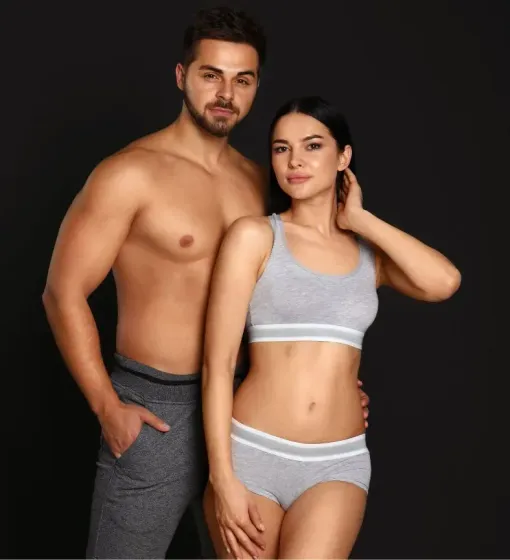Two adults in gray underwear posing against a black studio background.