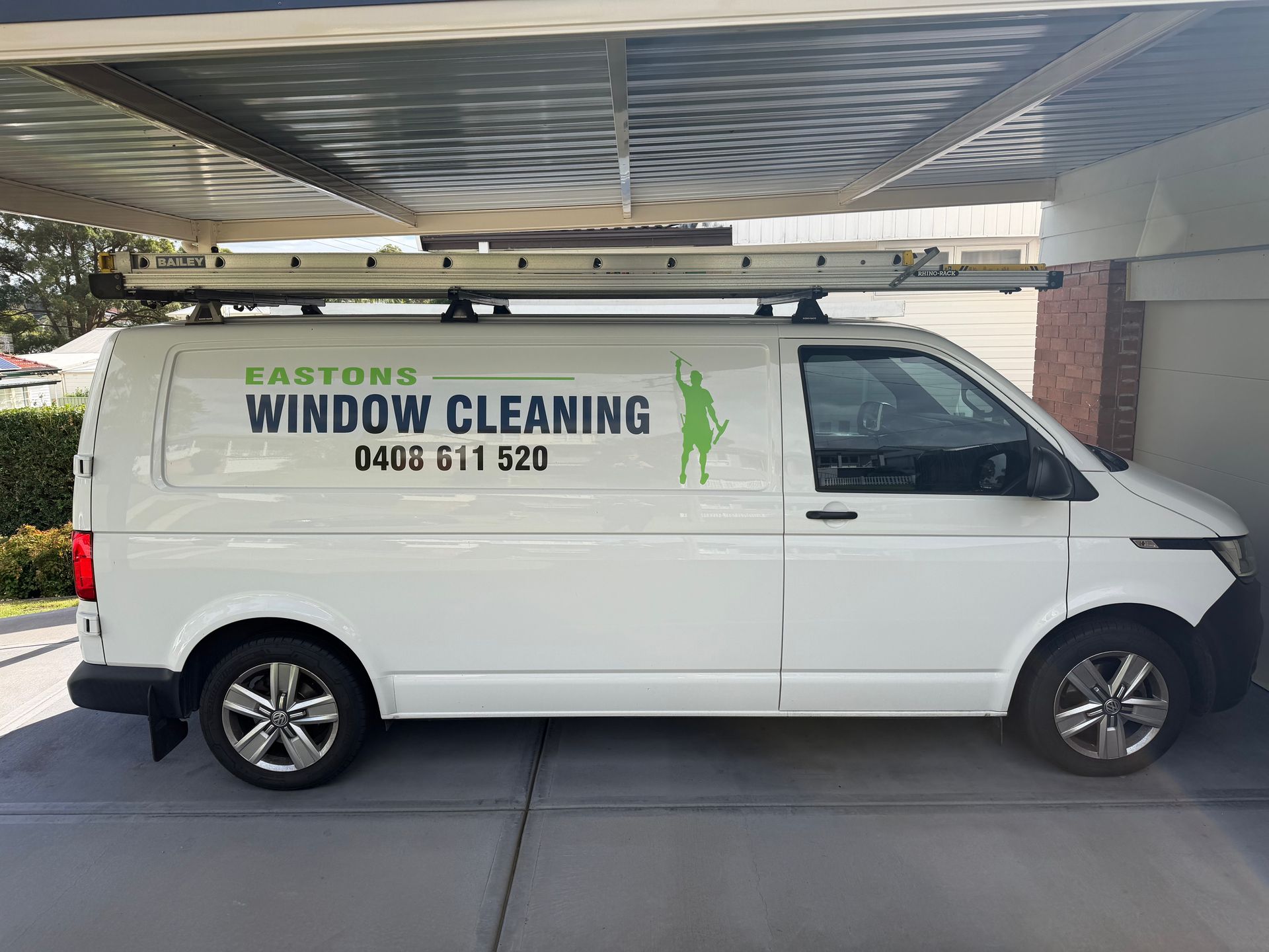 White Window Cleaning Van Parked In A Driveway Under A Carport — Eastons Window Cleaning in Cardiff, NSW