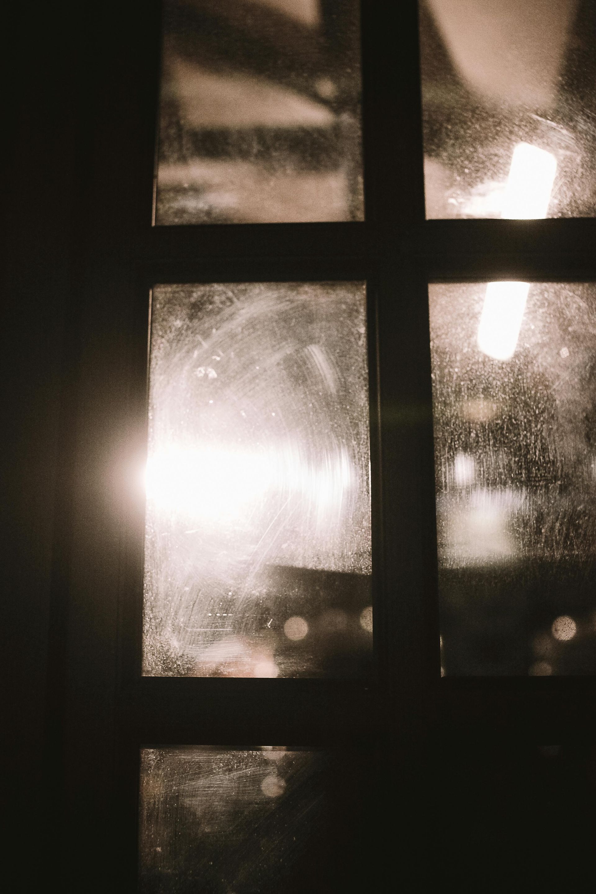 Bright Lights Seen Through a Dark Window with Crossbars at Night — Eastons Window Cleaning in Newcastle, NSW