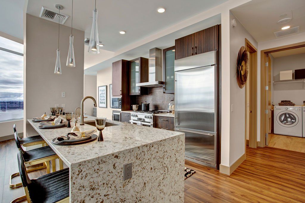 A kitchen with a large island and stainless steel appliances at Tower12 Apartments.