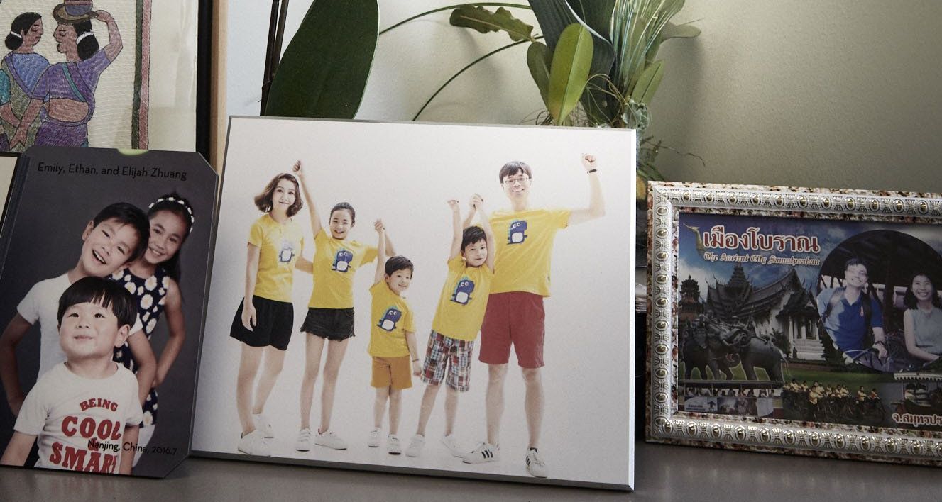 Three framed family photos displayed on a shelf, including a group portrait and a Disneyland scene.
