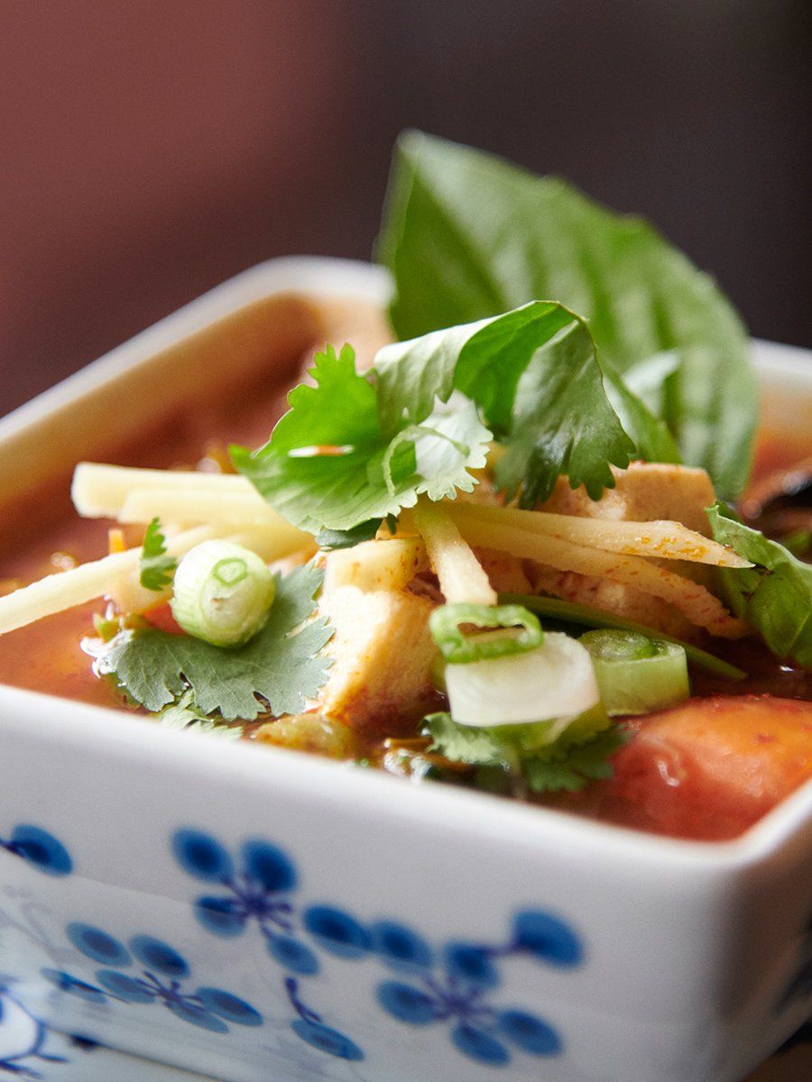 Small bowl of garnished soup with cilantro, green onions, and tofu cubes in a blue-and-white dish