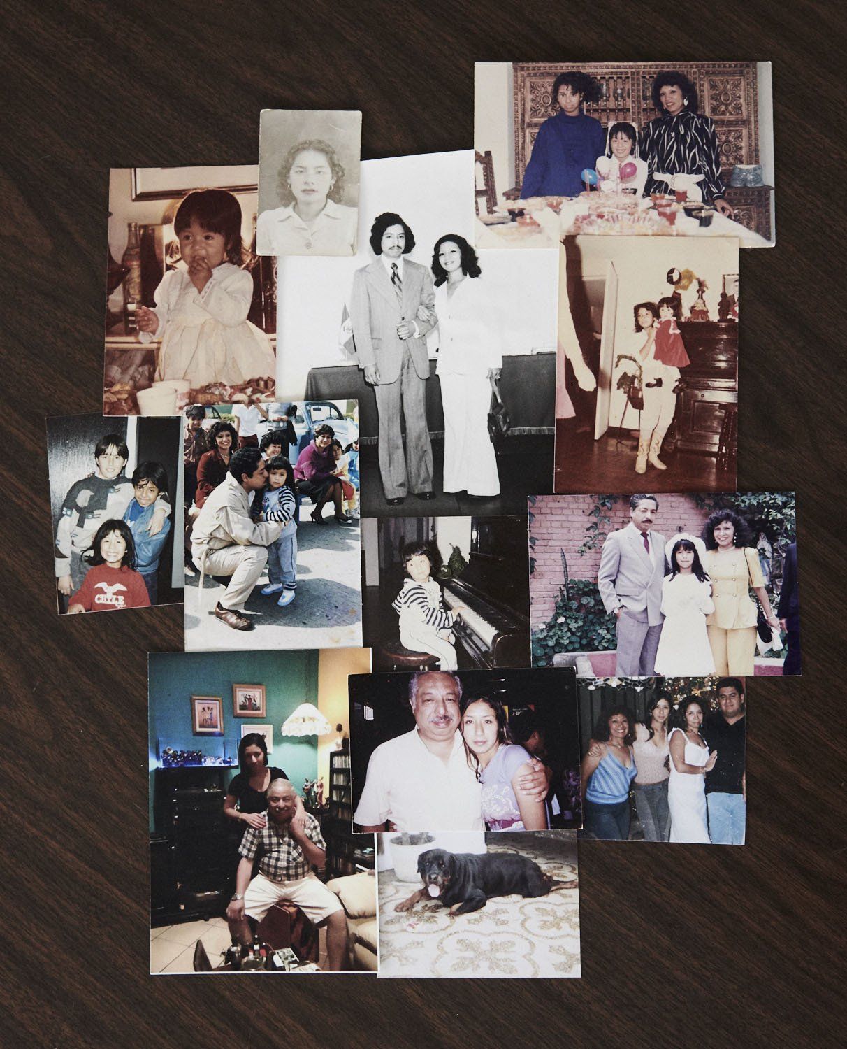 A collage of small family photos arranged on a dark tabletop, showing various posed snapshots.