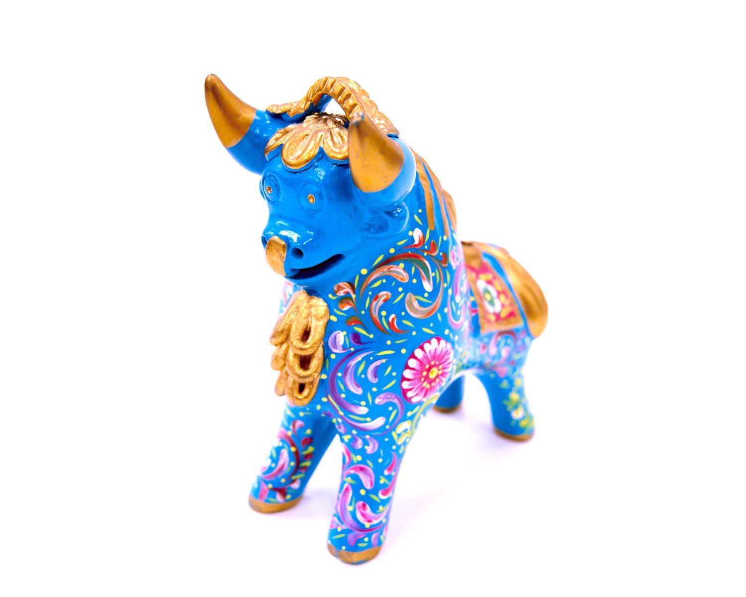 Blue decorative bull figurine with colorful floral patterns and gold horns, standing on a white background
