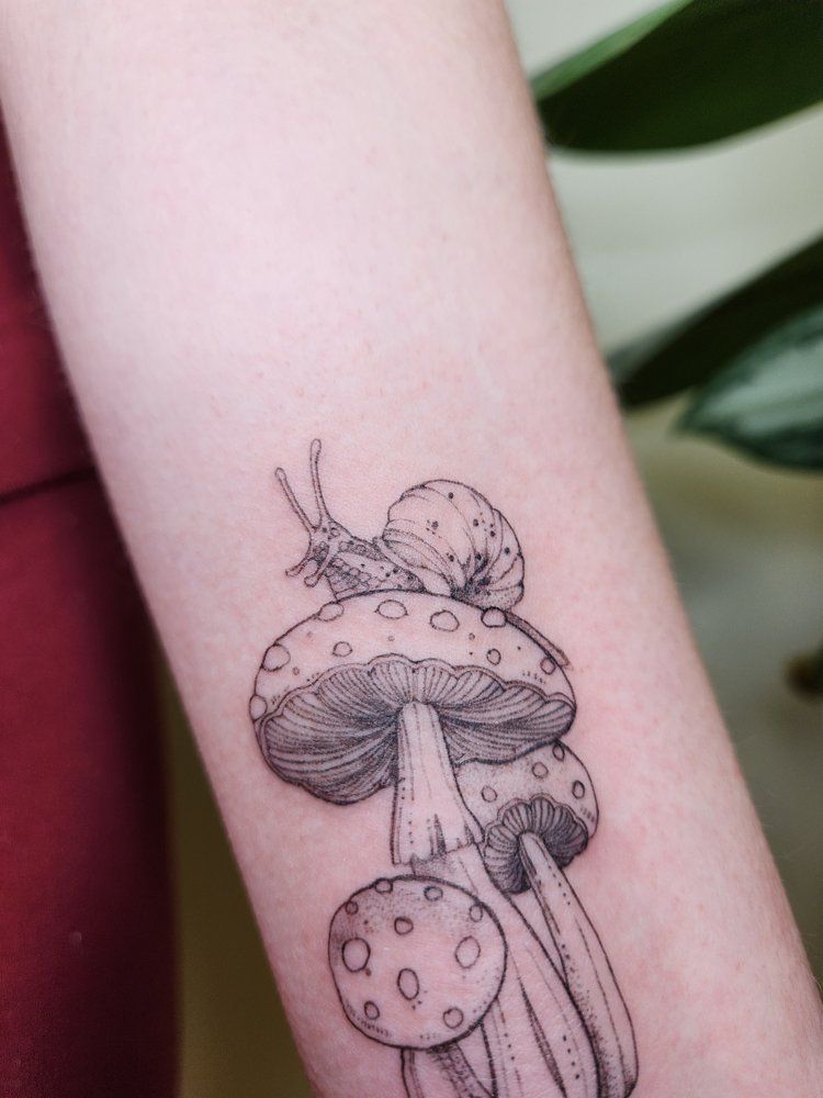 Mushroom tattoo with dotted caps and delicate linework on a forearm