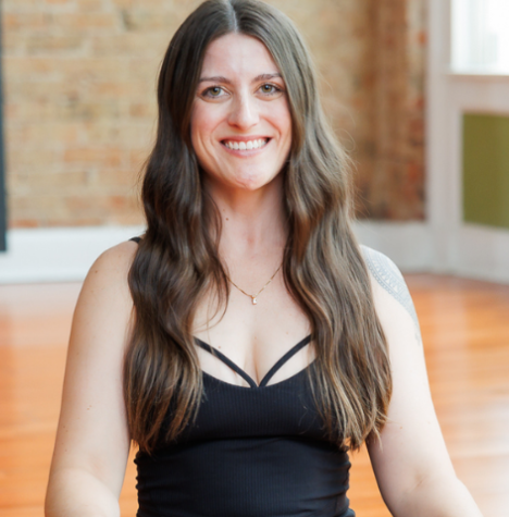 Headshot of Emilee Hamilton, 500 E-RYT yoga instructor specializing in anatomy and alignment, sitting inside the Uptown Yoga studio.