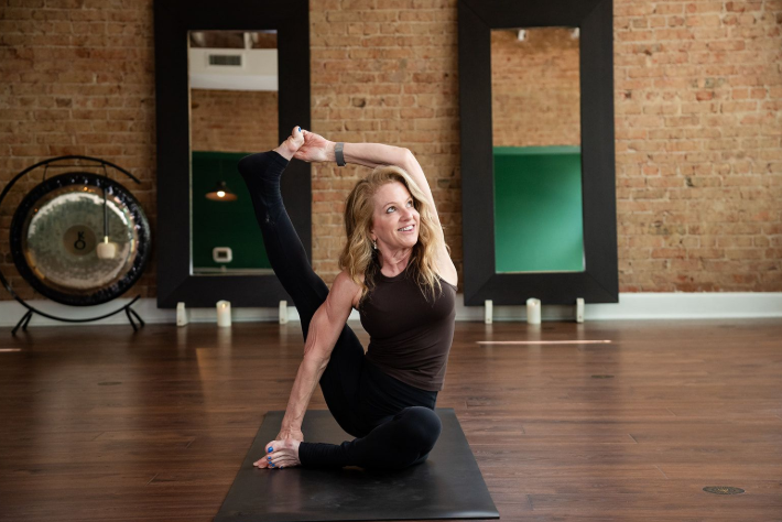 Uptown Yoga instructor Alice Laird demonstrating Compass Pose, sharing her transformative journey of finding yoga later in life.