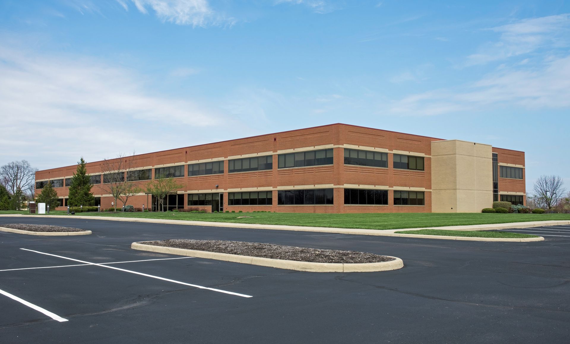 Freshly paved commercial asphalt parking lot with smooth black surface and crisp white striping