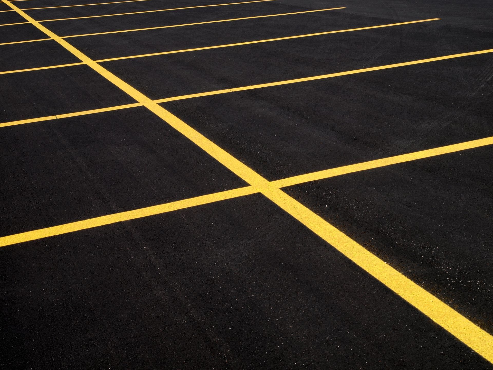 An aerial view of a road being paved with a yellow truck.